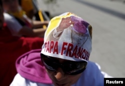 A woman waits for the arrival of Pope Francis at the Guadalupe's Basilica in Mexico City, Feb. 13, 2016.