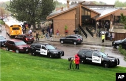 Police and others are seen outside STEM School Highlands Ranch, a charter middle school in the Denver suburb of Highlands Ranch, Colo., after a shooting May 7, 2019.