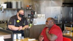 Kori Bruks naručuje hranu u restoranu Vafl Haus u Savani, u državi Džordžija gde su restorani počeli da primaju goste, ali uz ograničenja.