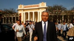 លោក សុរិយា ប្រាសាទ​ ស៊ូប៊ែឌី​ អ្នក​រាយការណ៍​ពិសេស​របស់​អង្គការ​សហ​ប្រជាជាតិ​ទទួល​បន្ទុក​សិទ្ធិ​មនុស្សប្រចាំ​ប្រទេស​កម្ពុជា ដើរ​ចេញ​ពី​សាលា​ឧទ្ធរណ៍​រាជធានី​ភ្នំពេញ​កាល​ពី​ថ្ងៃ​ទី​២២ ខែ​មករា ឆ្នាំ២០១៥ ​ដែល​នៅ​ទី​នោះ​លោក​បាន​ចូល​រួម​ស្តាប់​សវនាការ​សំណុំ​រឿង​សកម្មជន​ដី​ធ្លីនិង​ព្រះសង្ឈ​ទាំង​អស់​ចំនួន​១៩​នាក់​ដែល​ត្រូវ​បាន​កាត់​ទោស​កាល​ពី​ខែ​វិច្ឆិកា​ឲ្យ​ជាប់​ពន្ធនាគារ​ចំនួន​១​ឆ្នាំ។ (AP Photo/Heng Sinith)