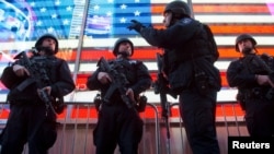Armed New York City police officers with the special operation division Strategic Response Group stand guard in Times Square in New York, as security was tightened following the deadly attacks in Paris, Nov. 14, 2015.