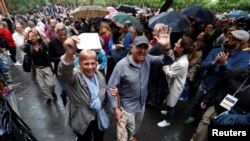 Voters are applauded as they leave a polling station for the banned independence referendum in Barcelona, Spain, Oct. 1, 2017.