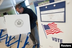 FILE - A voter casts his ballot behind a ballot booth during the U.S. presidential election at a polling station in the Staten Island Borough of New York, U.S.