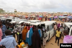 Somali Khat businesswomen waiting for khat stand near a mini bus in Mogadishu. Grown on plantations in the highlands of Kenya and Ethiopia, tonnes of khat, or qat, dubbed "the flower of paradise" by its users, are flown daily into Mogadishu airport, August 26, 2014.