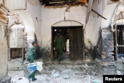 Soldiers enter a damaged building after an earthquake in Taik Kyi township in Myanmar, March 14, 2017.