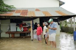 អ្នកស្រី ធូ ចាន់ណារី (អាវពណ៌ក្រហម) និងក្រុមគ្រួសារ ត្រៀមជន្លៀសខ្លួនពីផ្ទះរបស់ពួកគេដែលត្រូវបានទឹកជន់លិចខ្លាំង ទៅតំបន់ដីទួល នៅសង្កាត់ស្ពានថ្ម ខណ្ឌដង្កោរ ភ្នំពេញ ថ្ងៃទី១៤ ខែតុលា ឆ្នាំ២០២០។ (ទុំ ម្លិះ/វីអូអេ)