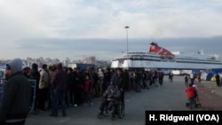 Refugees line up for food at Piraeus port, Athens, Greece, March 17, 2016.