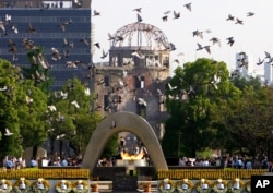 Doves fly during a ceremony at Hiroshima Peace Memorial Park in Hiroshima, Japan, Aug. 6, 2006.
