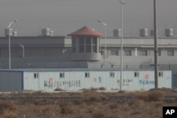 In this Monday, Dec. 3, 2018, photo, a guard tower and barbed wire fences are seen around a facility in the Kunshan Industrial Park in Artux in western China's Xinjiang region. This is one of a growing number of internment camps in Xinjiang.