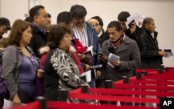 FILE - Nonresident visitors to the United States wait in line at immigration control after arriving at McCarran International Airport, in Las Vegas, Dec. 13, 2011.