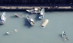 Penampakan dari udara yang menunjukkan perahu terbalik yang diyakini terkena dampak tsunami yang disebabkan oleh letusan gunung berapi bawah laut di Pulau Tonga di Pasifik Selatan, di Muroto, Prefektur Kochi, Jepang, 16 Januari 2022. (Foto: Kyodo via REUT
