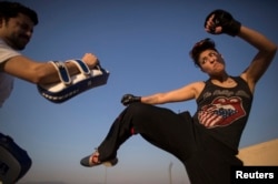FILE - Zahra Afridi (R) kicks a punching bag during a kickboxing training session at her home in Islamabad on February 10, 2014. (Reuters)