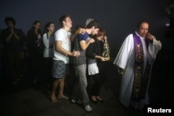 Relatives of Brazilian journalist Guilherme Marques, who died in a plane accident that crashed into Colombian jungle with Brazilian soccer team Chapecoense aboard near Medellin, mourn during a Mass in Rio de Janeiro, Brazil, Nov. 29, 2016.