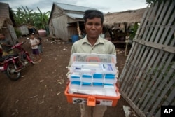 FILE - А malaria worker is seen carrying a traditional medicine kit in a village near Pailin, Cambodia, Aug. 29, 2009. Scientists have found that conventional kits could be replaced with artemisinin, a cheap but highly effective anti-malaria drug.