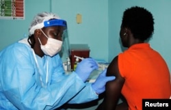 FILE - A health worker injects a woman with an Ebola vaccine during a trial in Monrovia, Feb. 2, 2015.