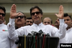 FILE - Cricket star-turned-politician Imran Khan, chairman of Pakistan Tehreek-e-Insaf (PTI), speaks to members of media after casting his vote at a polling station during the general election in Islamabad, Pakistan, July 25, 2018.