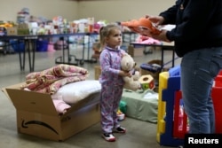 Emma Neurohr, 4, of Oroville, watches her mother at the Salvation Army relief center at the Placer County Fairgrounds in Roseville, California, after an evacuation was ordered for communities downstream from the dam in Oroville, Calif., Feb. 14, 2017.