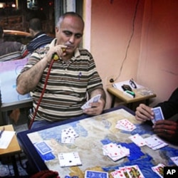Palestinian-American Ibrahim Mussa plays cards in a Ramallah cafe