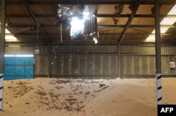 FILE - A pile of grains is seen at a damaged warehouse of Yemen's Red Sea Mills company in the port city of Hodeida, Jan. 22, 2019.