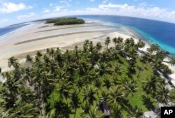 FILE - A large section of land between the trees washed away due to continuing rising sea levels on Majuro Atoll, Marshall, Nov. 6, 2015.