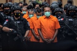 Petugas Kepolisian Indonesia mengawal tersangka penyelundup narkoba saat konferensi pers di Mabes Polri, setelah petugas berhasil mengamankan 2,5 ton sabu dari jaringan Timur Tengah, Malaysia, dan Indonesia, di Mabes Polri, 28 April 2021. (Antara Foto/M Risyal Hidayat/via REUTERS)