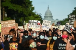 Protesters hold placards during a demonstration against the death of George Floyd while in Minneapolis police custody, in Washington, U.S., June 13, 2020.