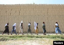 FILE - Taliban walk as they celebrate ceasefire in Ghanikhel district of Nangarhar province, Afghanistan, June 16, 2018.