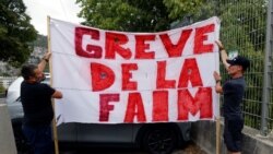 FILE - Protesters hold a banner which reads "Hunger strike" to demonstrate against France's restrictions to fight the coronavirus pandemic, near the Abbaye Saint-Pons in Nice, France, September 15, 2021.