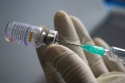 Seorang petugas kesehatan memegang jarum suntik dan botol vaksin Sinovac di sebuah pasar di Bangkok, Thailand, 17 Maret 2021. (Foto: REUTERS/Athit Perawongmetha)