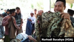 Para pengungsi memilih pakaian pantas pakai sumbangan para donatur.