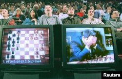 រូបភាព៖ ស្តេច​អុក​ពិភពលោក Garry Kasparov យក​ដៃ​ខ្ទប់​មុខ​ខណៈ​ពេល​ដែល​រូប​លោក​ត្រូវ​បាន​គេ​ដាក់​លើ​កញ្ចក់​ទូរទស្សន៍​ពេល​លោក​កំពុង​ប្រកួត​លេង​អុក​ជាមួយ​មហា​កុំព្យូទ័រ​របស់​ IBM​ ដែល​មាន​ឈ្មោះ​ថា Deep Blue ថ្ងៃ​ទី​១១ ខែ​ឧសភា ​ឆ្នាំ​១៩៩៧។ (Reuters)
