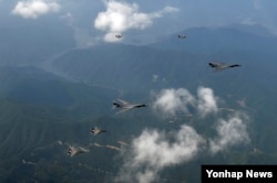 21일 괌에서 출격한 미국의 장거리 전략폭격기 B-1B 2대(가운데)가 주한미군 오산공군기지 상공에서 미군 F-16 전투기 2대(위), 한국군 F-15K 전투기 2대(아래)와 비행하고 있다.