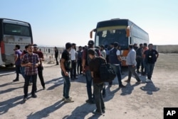 Rebels and their families arrive from the Damascus suburb of Daraya following a forced evacuation in Babiska, Idlib province, Syria, Aug. 27, 2016.