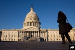 FILE - A woman looks at the U.S. Capitol in Washington.