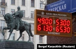 Sebuah layar yang dipasang di depan Monumen Pangeran Yury Dolgoruky di Moskow, menunjukkan nilai tukar mata uang asing Rusia dengan mata uang asing, pada 1 Desember 2014. (Foto: Reuters/Sergei Karpukhin)
