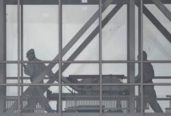 FILE - Medical staff members move a patient on a stretcher at the COVID-19 section at Kommunarka Hospital, outside Moscow, Russia, Oct. 5, 2021.