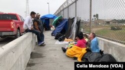 Migrants from Venezuela, Cuba and Guatemala wait at bridge between Matamoros, Mexico and Brownsville, Texas for immigration officials to allow them to turn themselves in and ask for asylum in US, Nov. 12, 2018.