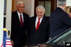 FILE - Vice President Mike Pence escorts Turkish Prime Minister Binali Yildirim to his car after a meeting at the White House in Washington, Nov. 9, 2017.