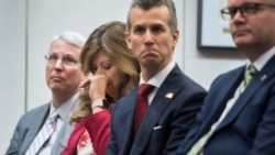 Susan Payne, founder and executive director of Safe2Tell wipes tears, as Peter Langman, left, Max Schachter, who lost his son Alex during the Parkland school mass shooting, center, and Ryan Petty, right, who lost his daughter Alaina.