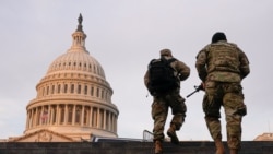 National Guard members walk at the Capitol, in Washington, U.S., January 15, 2021. REUTERS/Joshua Roberts