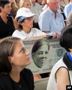 A woman holds a sign supporting Harriet Tubman for the $20 bill during a town hall meeting at the Women's Rights National Historical Park in Seneca Falls, N.Y.