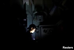 Female IT specialist Airi Azumai checks communication cables on Japanese helicopter carrier Kaga in the Indian Ocean, Indonesia, Sept. 24, 2018.