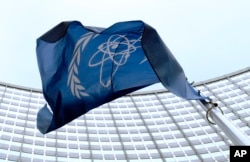 FILE - The flag of the International Atomic Energy Agency (IAEA) flies in front of the Vienna headquarters at the Vienna International Center, March 27, 2009.