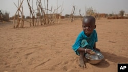 FILE - А boy is seen eating dry couscous in the village of Goudoude Diobe, in the Matam region of northeastern Senegal.