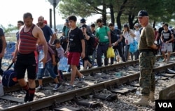Migrants walk near a camp in the southern Macedonian town of Gevgelija, Sept. 11, 2015.