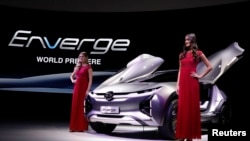 Des modèles posant avec le concept-car électrique GAC Enverge au Salon de Detroit, le 15 janvier 2018.