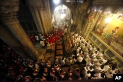 Christian clergymen carry palm fronds during the Palm Sunday procession in the Church of the Holy Sepulcher, traditionally believed by many to be the site of the crucifixion, in Jerusalem's Old City, March 20, 2016.