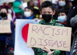 Ethan Yang, 11, memegang tanda bertuliskan "rasisme adalah penyakit" selama unjuk rasa "Anak vs. Rasisme" melawan kejahatan rasial anti-Asia di Hing Hay Park di Chinatown-International District of Seattle, Washington, AS, 20 Maret 2021 (Foto: REUTERS/Lind
