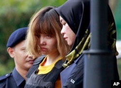 FILE - Vietnamese suspect Doan Thi Huong, center, is escorted by police officers out from Sepang court in Sepang, Malaysia, March 1, 2017.