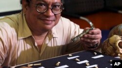 Filipino archeologist Armand Salvador Mijares shows bones and teeth they recovered from Callao Cave belonging to a new specie they called Homo luzonensis during a press conference in metropolitan Manila, Philippines on Thursday, April 11, 2019. (AP Photo)